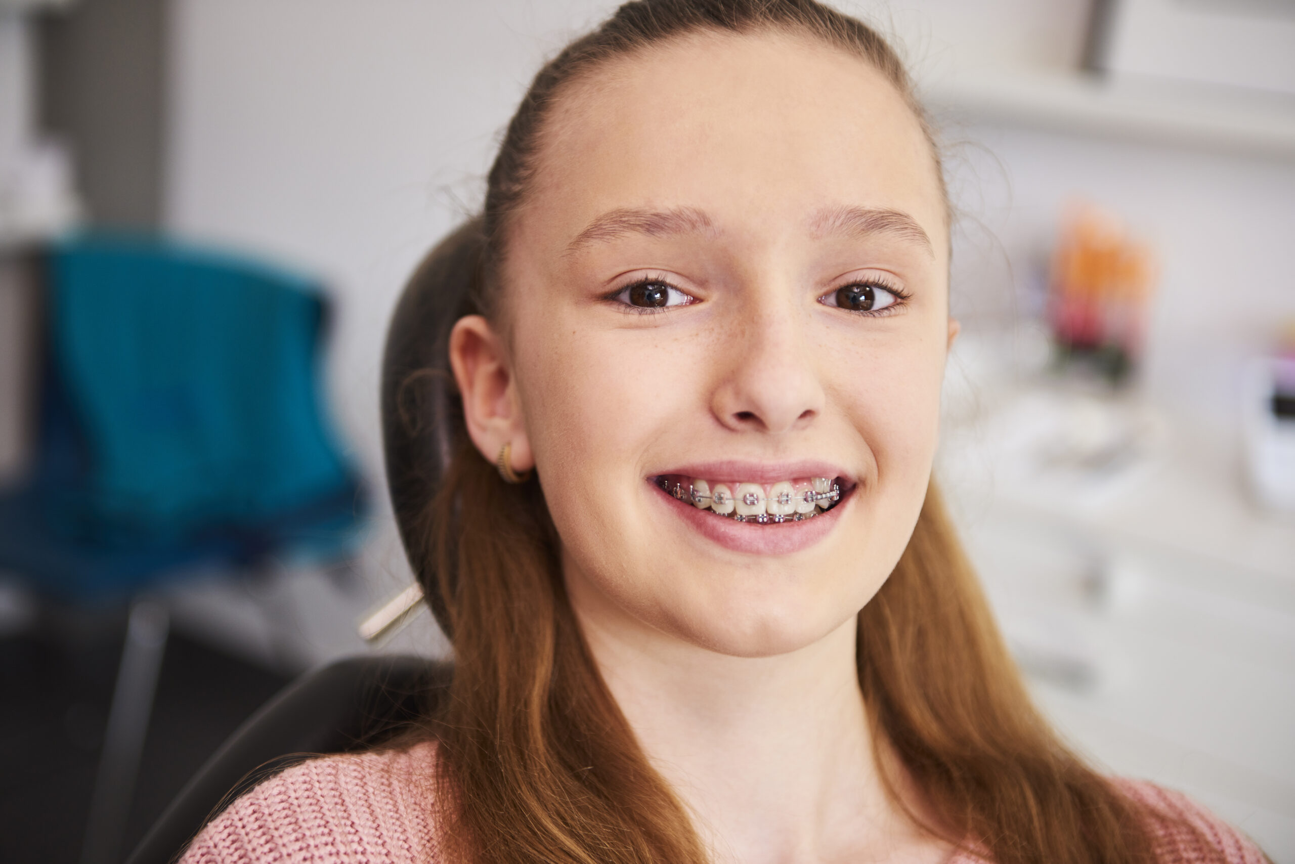 Child sitting in dentist chair getting braces at the best price.
